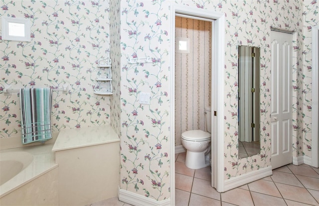 649 Crossfield Cir Unit 10, Venice, FL 34293 - bathroom featuring toilet, tile patterned flooring, wallpapered walls, and a bath