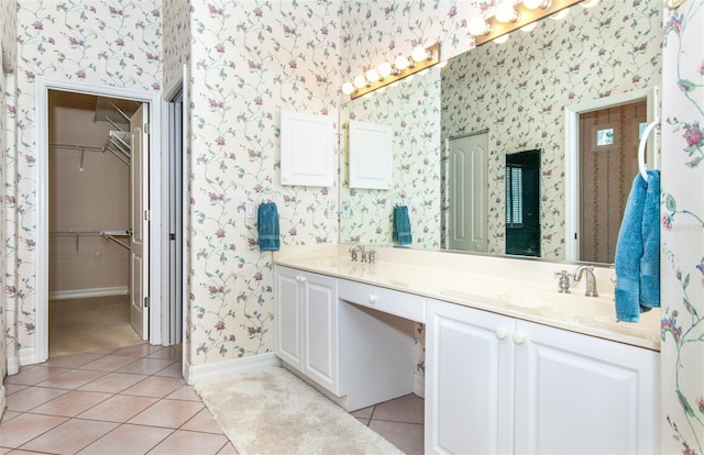 649 Crossfield Cir Unit 10, Venice, FL 34293 - bathroom featuring wallpapered walls, tile patterned floors, double vanity, baseboards, and a walk in closet