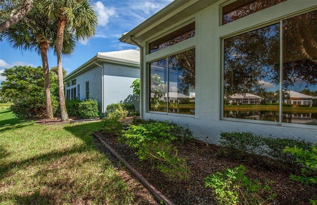 649 Crossfield Cir Unit 10, Venice, FL 34293 - view of property exterior featuring stucco siding, a water view, and a yard