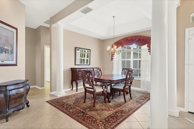 tiled dining space with a raised ceiling, decorative columns, and a chandelier