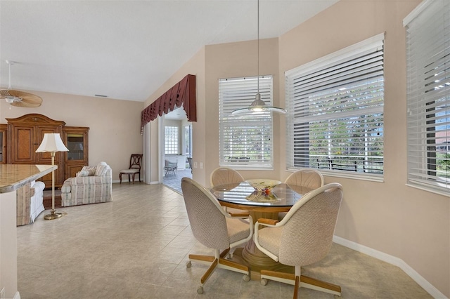 tiled dining space with ceiling fan and lofted ceiling