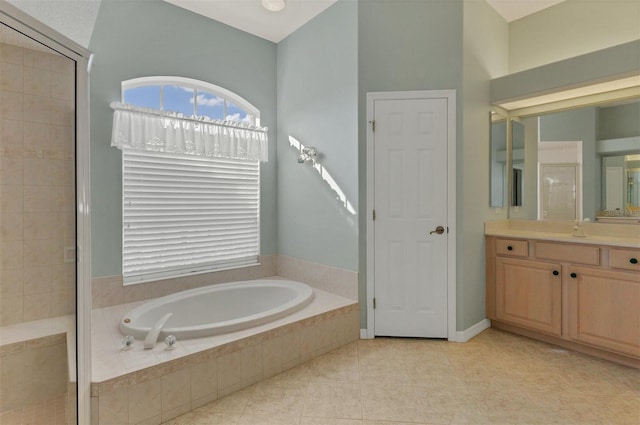 bathroom featuring vanity, a relaxing tiled tub, and tile patterned floors