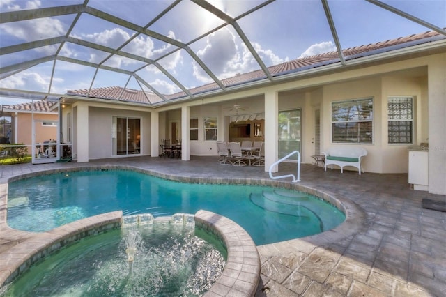 view of pool featuring ceiling fan, an in ground hot tub, a patio, and glass enclosure