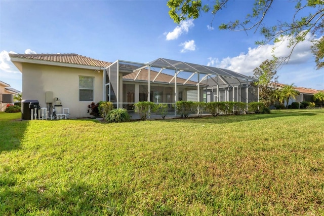 rear view of house with a lawn, glass enclosure, and cooling unit