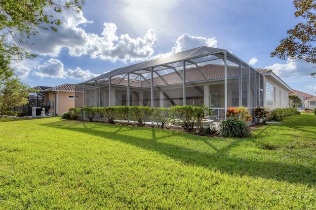 rear view of house with a lanai and a yard