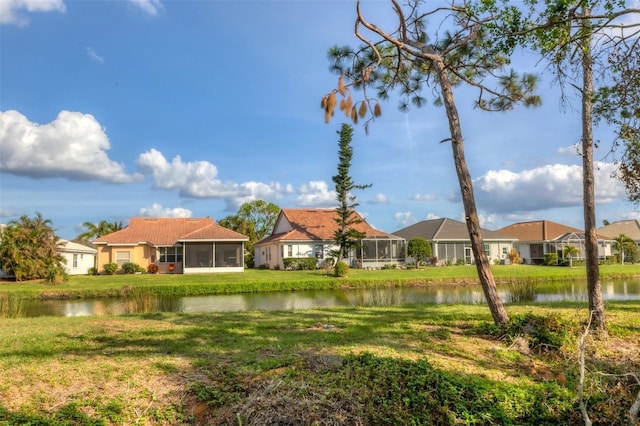 view of yard featuring a water view and a sunroom