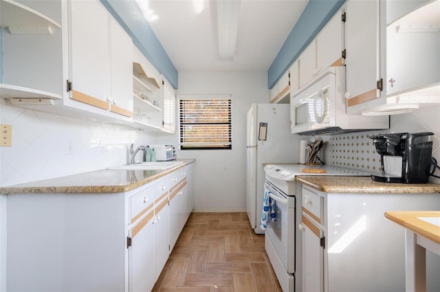 kitchen with white appliances, backsplash, sink, white cabinetry, and light parquet flooring