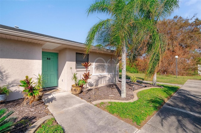 entrance to property with a lawn