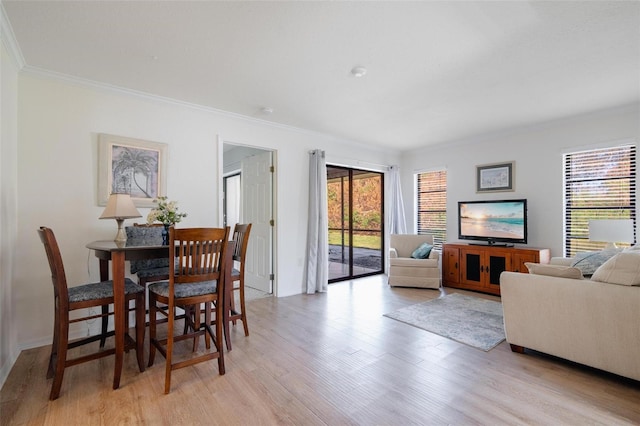 dining area with light hardwood / wood-style flooring and ornamental molding