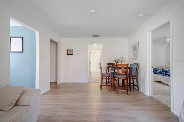 dining space with light hardwood / wood-style floors, ornamental molding, and ceiling fan