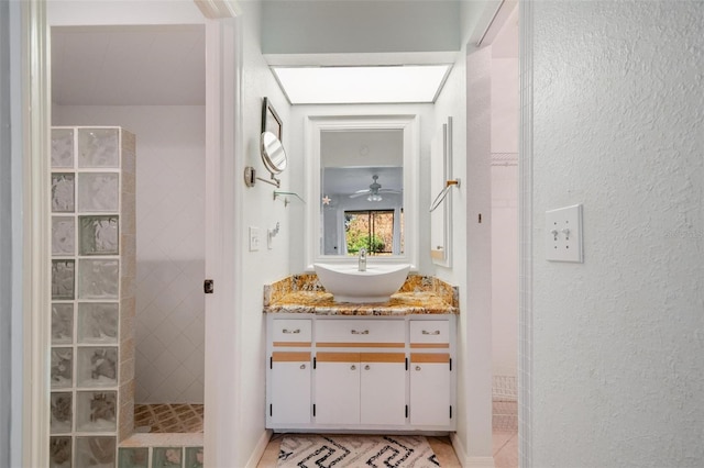 bathroom featuring vanity, a tile shower, and ceiling fan