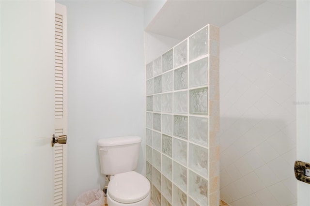 bathroom with toilet and tiled shower