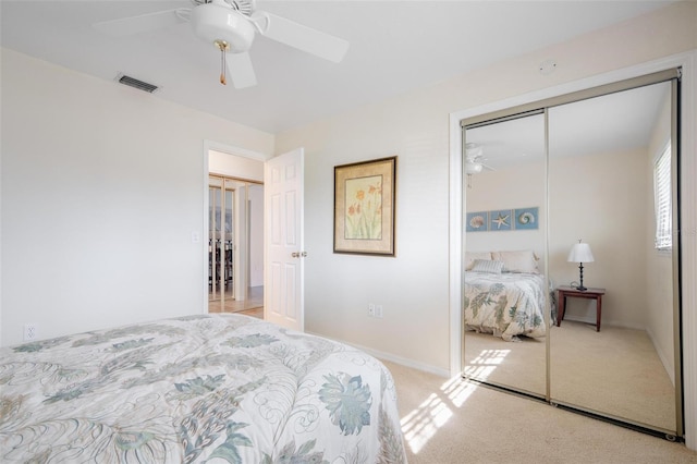 bedroom featuring a closet, light colored carpet, and ceiling fan