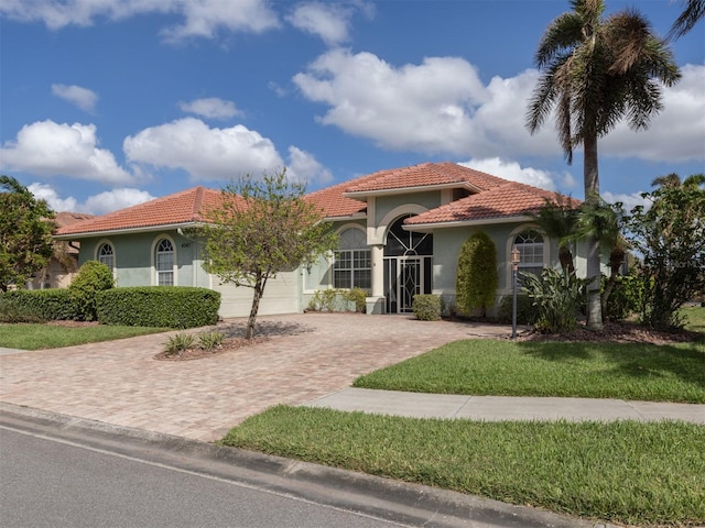 mediterranean / spanish-style house featuring a garage and a front yard