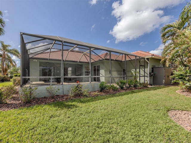 back of property featuring glass enclosure and a yard