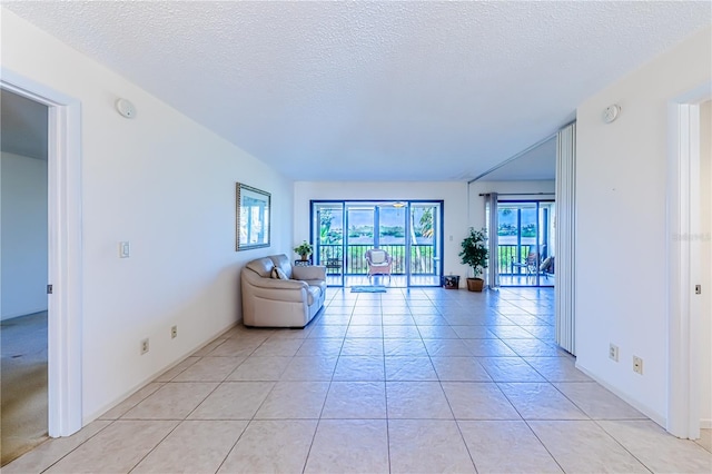 unfurnished living room featuring light tile patterned flooring and a textured ceiling