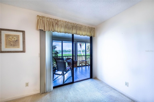 carpeted empty room featuring a textured ceiling