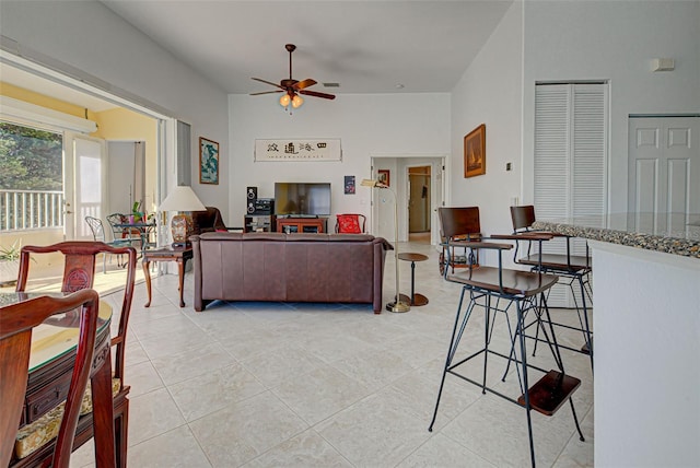 tiled living room with french doors and ceiling fan