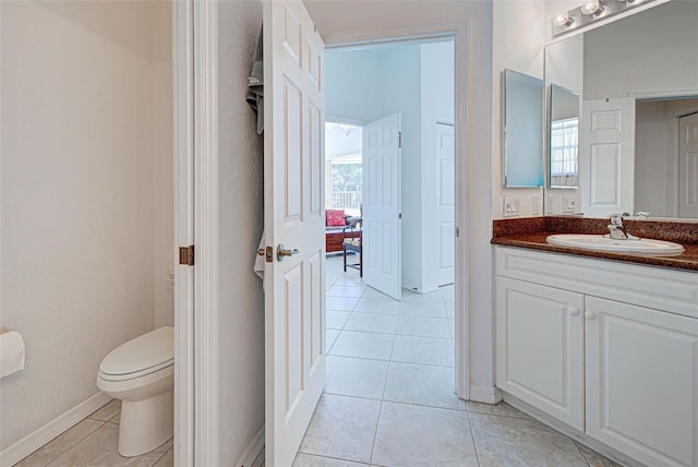 bathroom with vanity, toilet, tile patterned floors, and a wealth of natural light