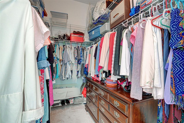 walk in closet featuring light colored carpet