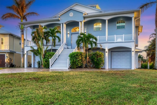 view of front of property featuring a lawn, a garage, and covered porch