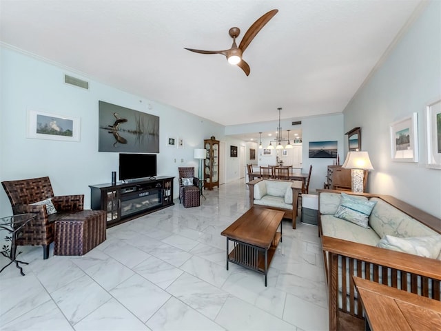 living room with ornamental molding and ceiling fan with notable chandelier