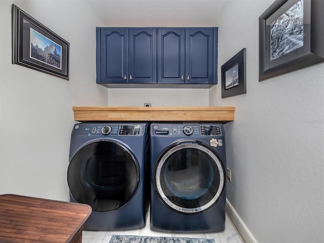 clothes washing area with light tile patterned flooring, washing machine and clothes dryer, and cabinets