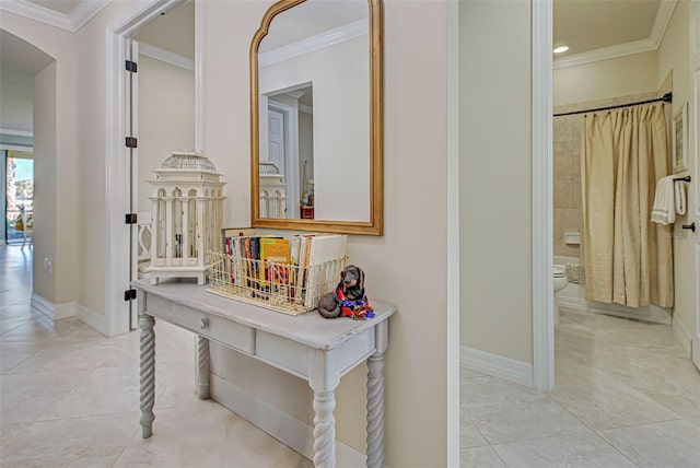 corridor featuring ornamental molding and light tile patterned flooring