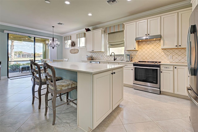 kitchen with stainless steel appliances, a center island, sink, ornamental molding, and pendant lighting