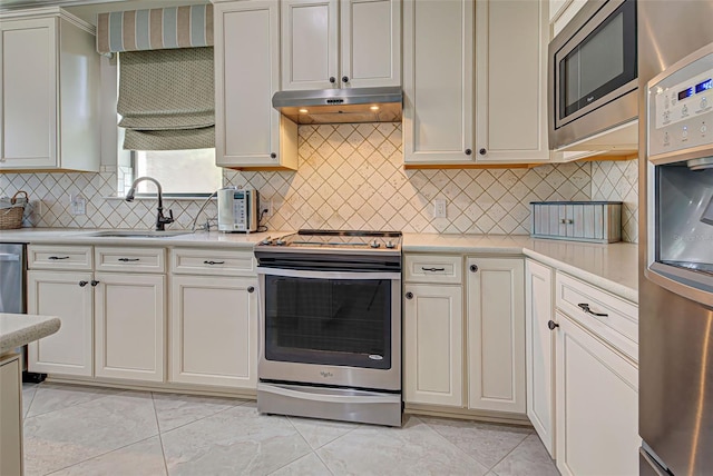 kitchen with backsplash, sink, light tile patterned floors, and stainless steel appliances