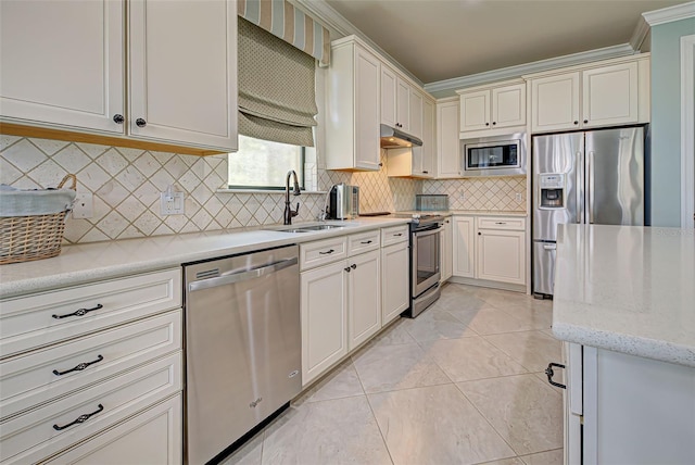 kitchen featuring backsplash, sink, crown molding, and stainless steel appliances