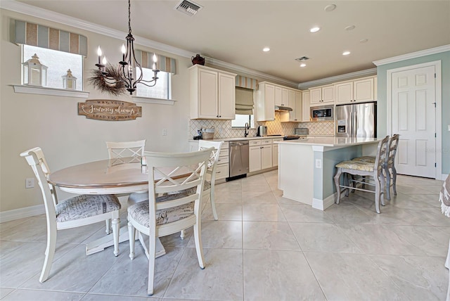 kitchen featuring a kitchen island, pendant lighting, appliances with stainless steel finishes, and crown molding