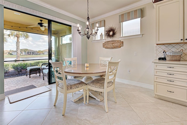 tiled dining space featuring ceiling fan with notable chandelier and ornamental molding