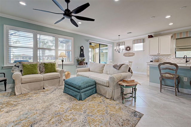 tiled living room featuring ceiling fan with notable chandelier, sink, and crown molding