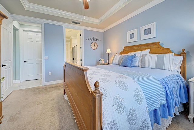 bedroom with ceiling fan, a raised ceiling, crown molding, and light colored carpet