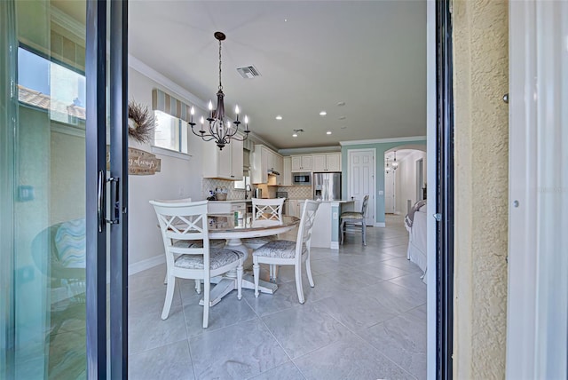 dining space featuring a notable chandelier and crown molding