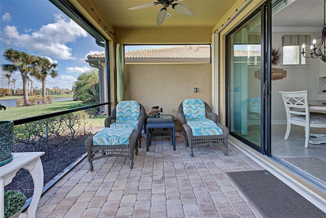 sunroom / solarium with ceiling fan with notable chandelier