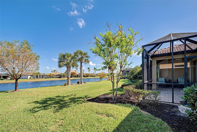 view of yard featuring a water view and glass enclosure