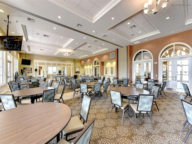 dining space featuring a towering ceiling, plenty of natural light, french doors, and a tray ceiling