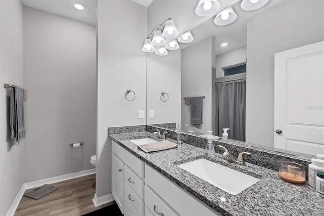 bathroom featuring curtained shower, hardwood / wood-style floors, vanity, and toilet