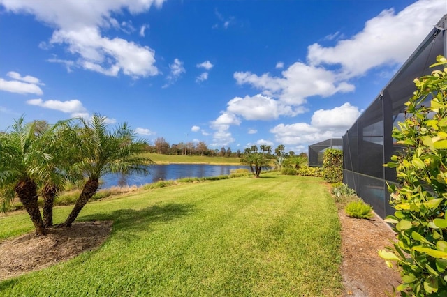 view of yard with glass enclosure and a water view