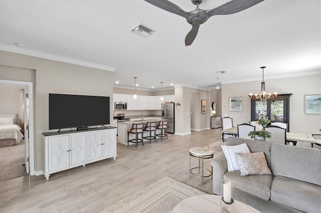 living room with sink, ceiling fan with notable chandelier, and ornamental molding