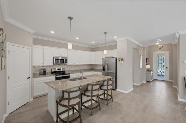 kitchen with white cabinetry, an island with sink, stainless steel appliances, decorative light fixtures, and sink