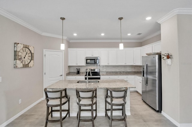 kitchen featuring decorative light fixtures, sink, white cabinetry, and stainless steel appliances