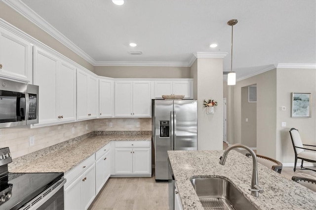 kitchen with stainless steel appliances, hanging light fixtures, white cabinets, light stone counters, and sink