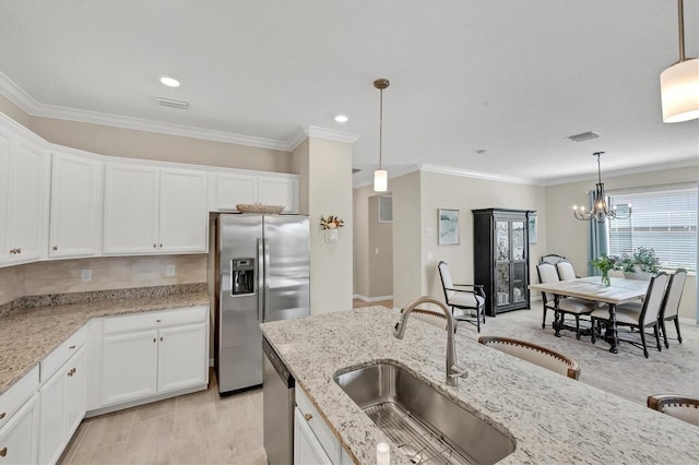 kitchen with stainless steel appliances, white cabinets, hanging light fixtures, and sink