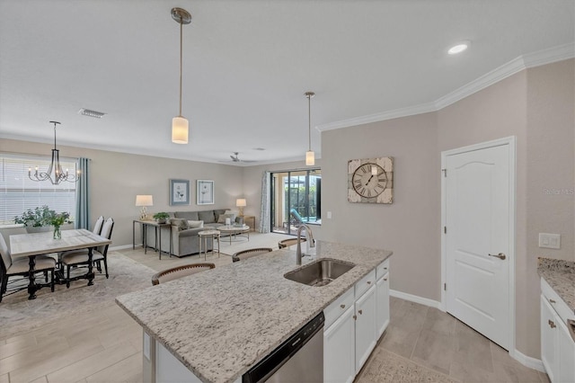 kitchen with an island with sink, pendant lighting, stainless steel dishwasher, white cabinets, and sink