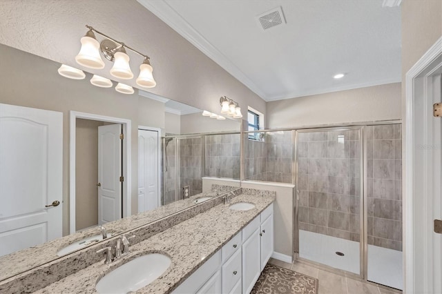 bathroom featuring tile patterned floors, crown molding, a shower with shower door, and vanity