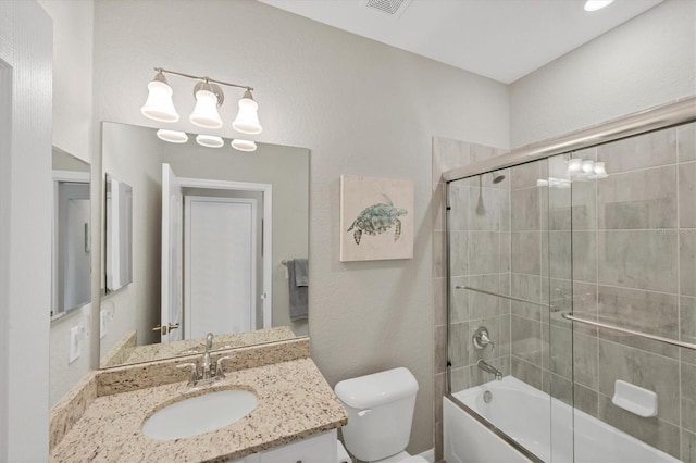 full bathroom featuring toilet, bath / shower combo with glass door, and vanity