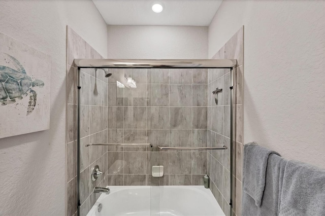 bathroom with bath / shower combo with glass door